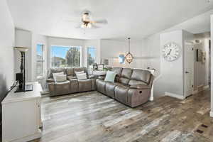 Living area with wood finished floors, a chandelier, and ceiling fan