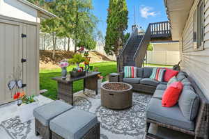 View of patio / terrace featuring an outdoor living space with a fire pit, stairs, and a deck