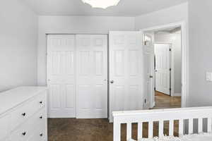 Unfurnished bedroom with a closet and dark carpet