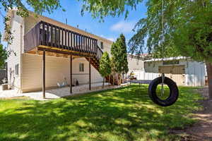 Back of house with  a wooden deck, stairway, and a storage shed