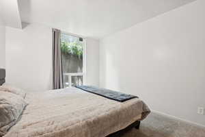 Bedroom featuring carpet and baseboards