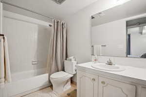 Full bathroom with shower / bathtub combination with curtain, vanity, and tile patterned flooring