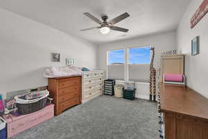 Bedroom with carpet flooring, a textured ceiling, and ceiling fan