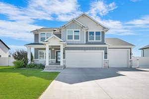 Craftsman house featuring board and batten siding, concrete driveway, a garage, and stone siding