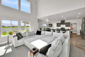 Living area featuring recessed lighting, wood finished floors, and a towering ceiling