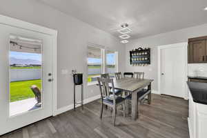 Dining space with dark wood-type flooring