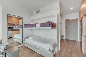 Bedroom featuring light wood-type flooring, freestanding refrigerator, and recessed lighting