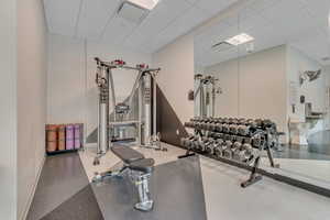 Workout area featuring baseboards and a drop ceiling