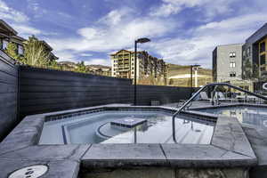 View of swimming pool with an outdoor hot tub and a fenced backyard