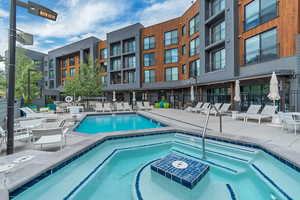 Community pool featuring a hot tub and a patio