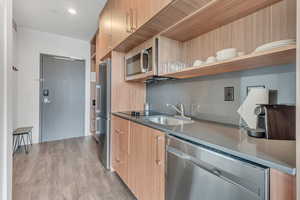 Kitchen with open shelves, modern cabinets, appliances with stainless steel finishes, and light wood finished floors