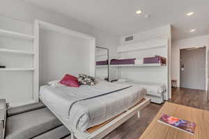 Bedroom with dark wood-style flooring and recessed lighting