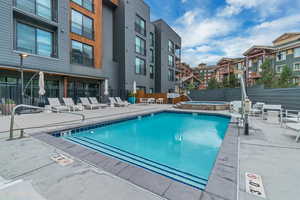 Community pool featuring a community hot tub and a patio area