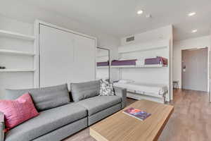 Living area with wood finished floors and recessed lighting