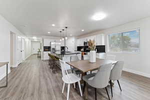 Dining area with light wood-style floors and recessed lighting
