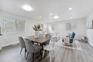 Dining space with plenty of natural light, wood finished floors, and recessed lighting