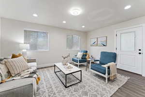 Living area with wood finished floors, healthy amount of natural light, and recessed lighting