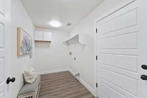 Laundry area featuring dark wood-type flooring and electric dryer hookup