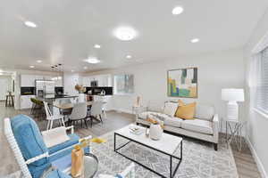 Living room with light wood-style flooring and recessed lighting