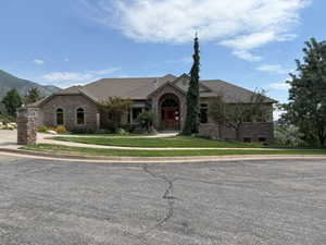 French country home featuring brick siding, a front lawn, and a shingled roof