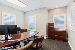 Office with dark carpet and recessed lighting