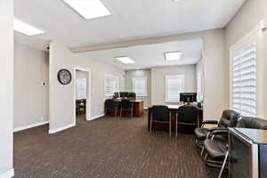 Office space featuring a textured ceiling and carpet floors