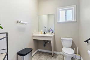 Half bath featuring toilet and tile patterned floors