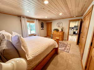 Bedroom with wood ceiling, recessed lighting, and light colored carpet