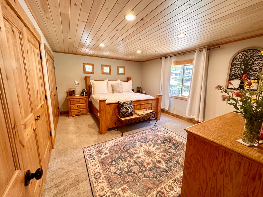 Bedroom featuring recessed lighting, wooden ceiling, light carpet, and ornamental molding