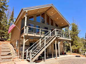 Rear view of house with stone siding and a patio