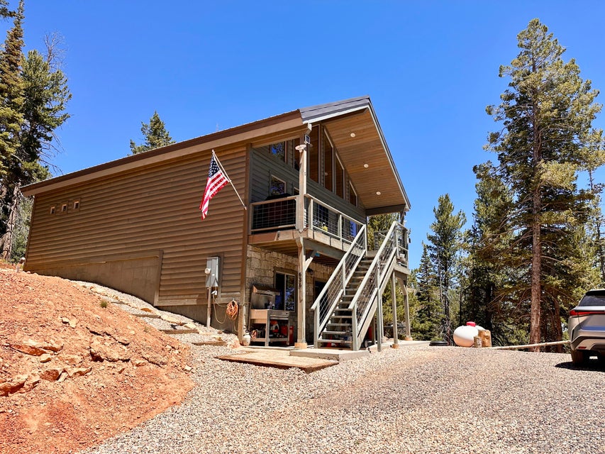 Back of house with stairway, driveway, and a wooden deck