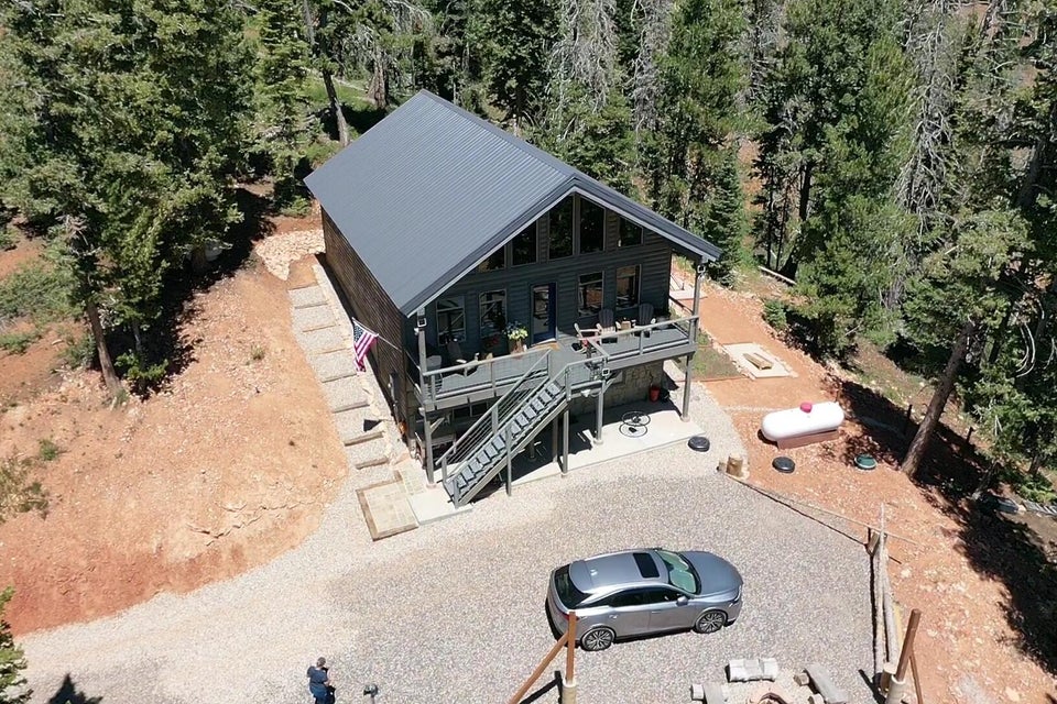 Aerial view of property and surrounding area featuring a heavily wooded area
