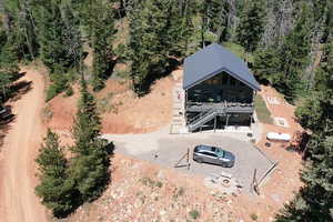 Aerial view of property and surrounding area with a forest