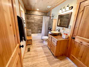 Bathroom featuring vanity, shower / bath combo with shower curtain, wooden ceiling, and wood finished floors