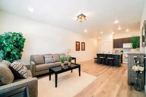 Living room with light wood finished floors and recessed lighting