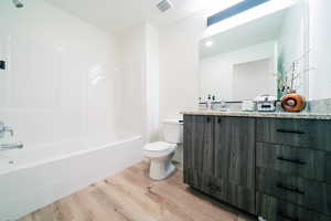 Full bathroom with wood finished floors, vanity, and  shower combination