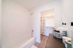 Bathroom featuring shower / bath combination and wood finished floors