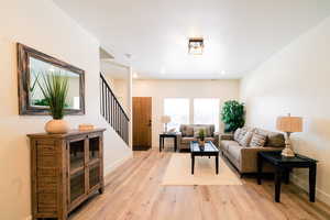 Living room with stairs and light wood-style flooring