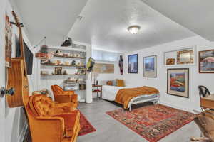 Bedroom with a textured ceiling and wood finished floors