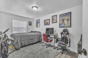 Bedroom featuring a textured ceiling and wood finished floors
