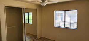 Unfurnished bedroom featuring a closet, wood finished floors, and ceiling fan