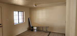Empty room with light tile patterned flooring and baseboards