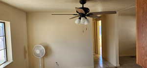 Spare room featuring a ceiling fan, light tile patterned flooring, and a textured ceiling
