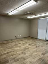 Empty room featuring a textured ceiling and wood finished floors