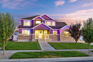 Craftsman-style home featuring a front yard and brick siding