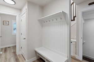 Mudroom featuring light wood-type flooring and baseboards