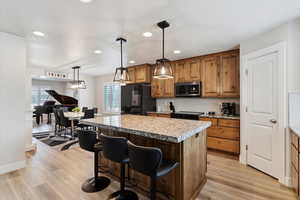 Kitchen with a center island, healthy amount of natural light, decorative backsplash, fridge, and recessed lighting