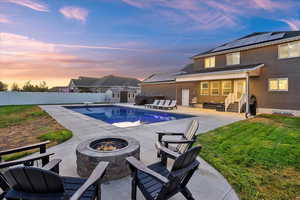 View of swimming pool with a storage unit, a fenced backyard, a patio, a diving board, and an outdoor living space with a fire pit