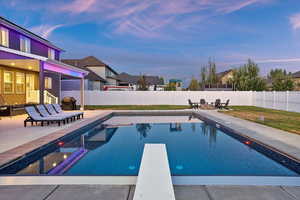 View of swimming pool with a patio area, a fenced backyard, a diving board, and a grill