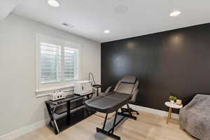 Sitting room with light wood-type flooring and recessed lighting